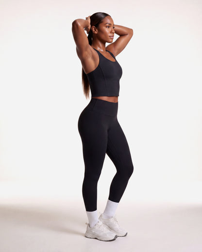 VARCEA Seamless High Tank in black — lifestyle, arms raised